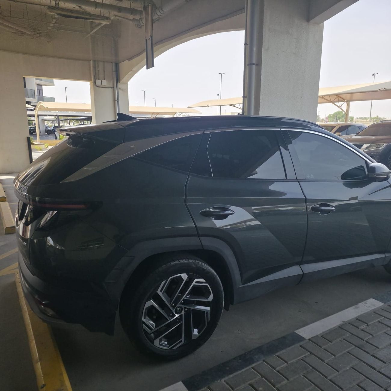 Hyundai Tucson PREMIUM PLUS An olive green car.