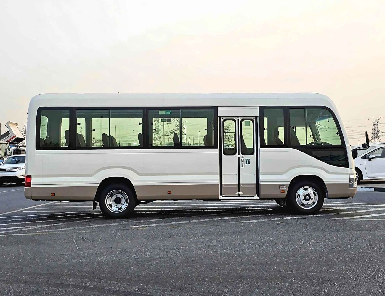 تويوتا كوستر 2.7L PETROL M/T DUAL TONE / 23 SEATER / AUTO DOOR / HLF LUGGAGE RACK (CODE#COPB)
