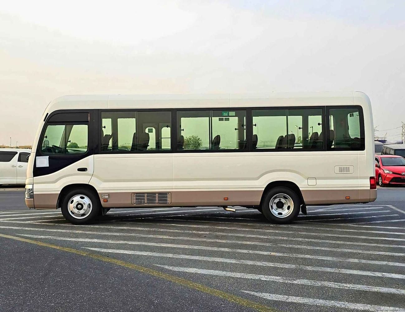 تويوتا كوستر 2.7L PETROL M/T DUAL TONE / 23 SEATER / AUTO DOOR / HLF LUGGAGE RACK (CODE#COPB)